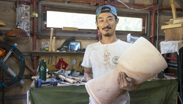 完成したジャンベを持ち、笑う木村さん。作成した後、太鼓を乾燥させて太鼓は完成する。