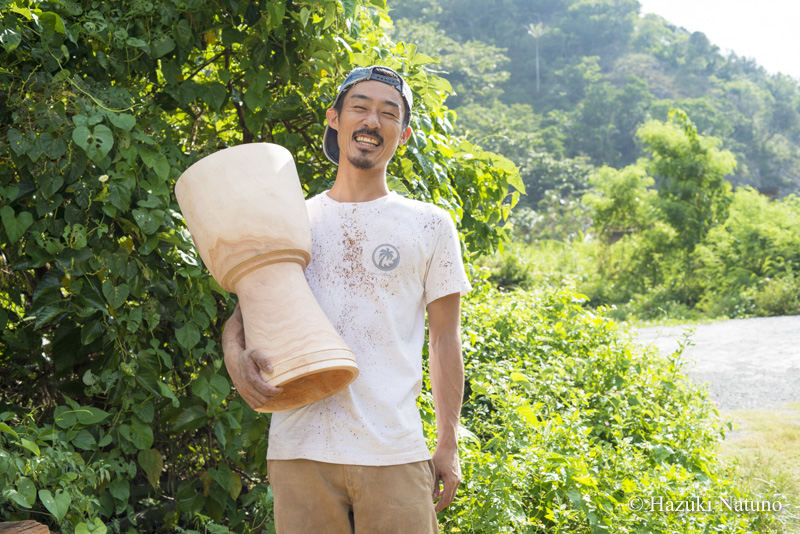 自作したジャンベを持ち、笑う木村さん。作成した後、木を乾燥させて太鼓は完成する。